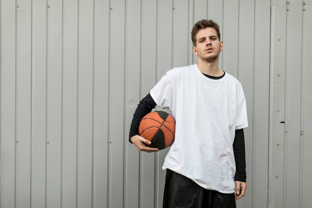 Vooraanzicht man poseren met een basketbal