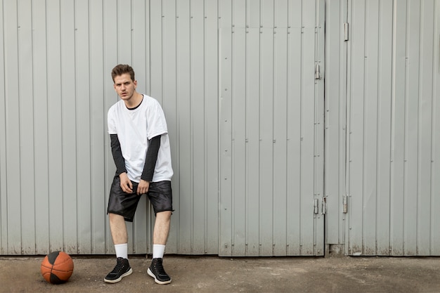 Vooraanzicht man poseren met een basketbal