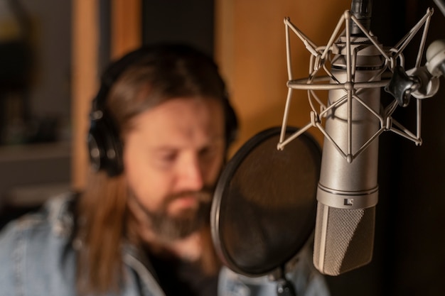 Gratis foto vooraanzicht man zingen in de studio