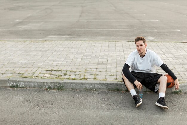 Vooraanzicht man zit met een basketbal