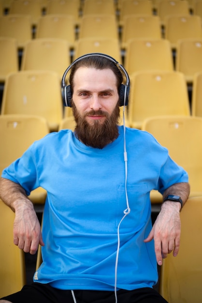 Gratis foto vooraanzicht man zittend op tribunes