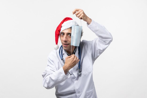 Vooraanzicht mannelijke arts met masker op witte muur covid nieuwjaar vakantie virus