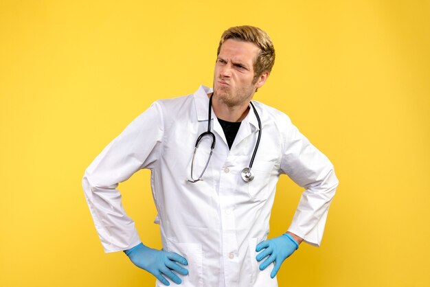 Vooraanzicht mannelijke arts op gele achtergrond gezondheid medicus virus
