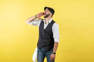 Gratis foto vooraanzicht mannelijke barman die iemand belt op gele muurmodel drankje werkclub mannelijke nachtbaan