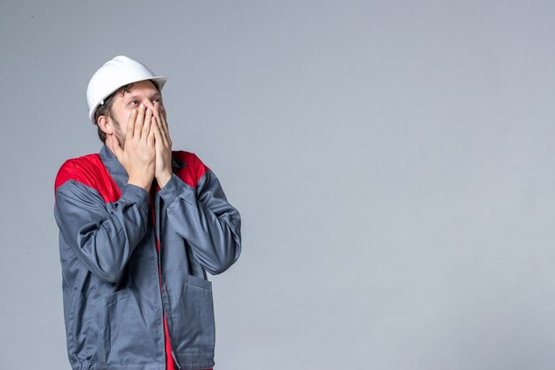 vooraanzicht mannelijke bouwer in uniform emotioneel op lichte achtergrond