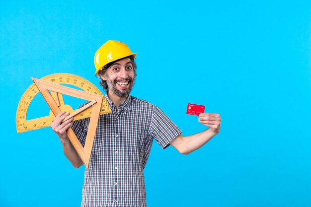 Vooraanzicht mannelijke bouwer met houten figuren en bankkaart op blauw