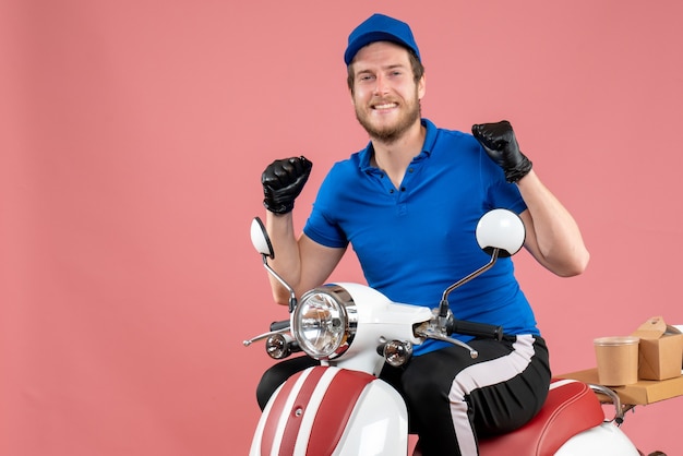 Vooraanzicht mannelijke koerier in blauw uniform en handschoenen op roze kleur fast-food service food job bezorgfiets