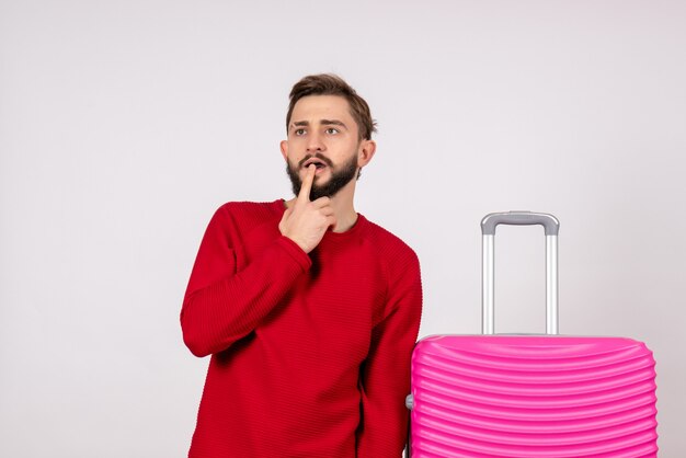 Vooraanzicht mannelijke toerist met roze tas op witte muur