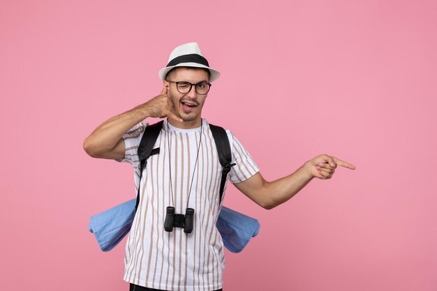 Vooraanzicht mannelijke toerist poseren met rugzak op roze muur kleur emoties toerist