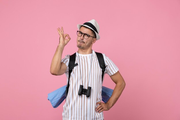 Vooraanzicht mannelijke toerist wandelen met rugzak op de roze muur kleur emotie toerist