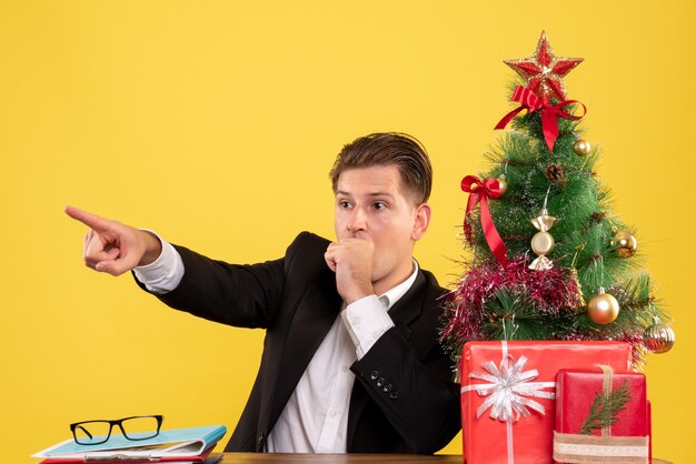 Vooraanzicht mannelijke werknemer achter zijn werktafel