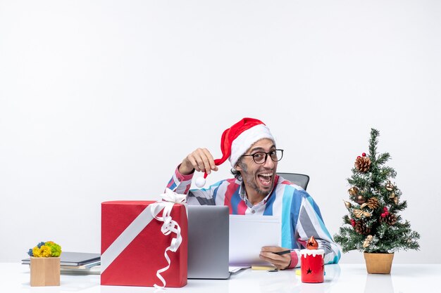 Vooraanzicht mannelijke werknemer zittend op zijn plaats met laptop en bestanden met documenten xmas office