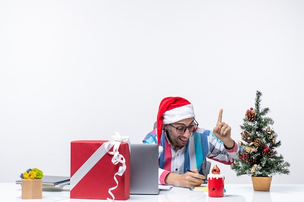 Vooraanzicht mannelijke werknemer zittend op zijn werkplek aantekeningen schrijven zakelijke baan kerst emotie