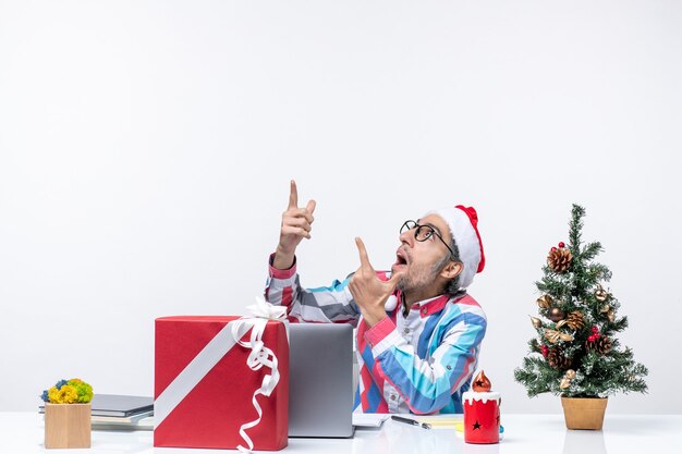 Vooraanzicht mannelijke werknemer zittend op zijn werkplek kantoorbaan kerst zakelijke emotie