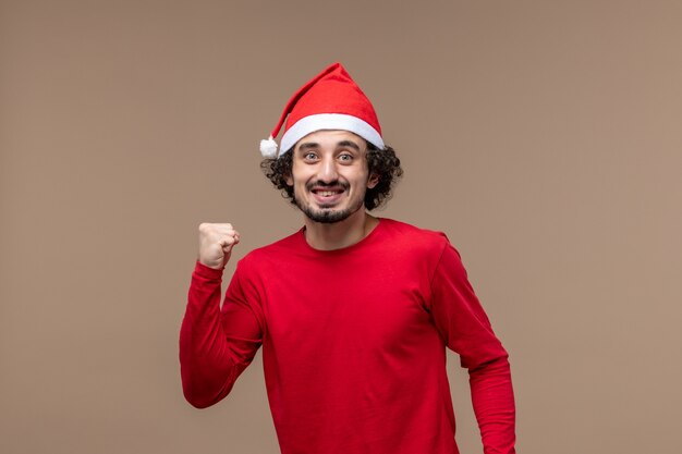Vooraanzicht mannetje in rood met opgewonden uitdrukking op bruine achtergrond vakantie emotie kerstmis