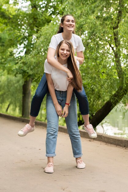 Vooraanzicht meisje met haar vriend op haar rug