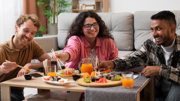 Vooraanzicht mensen die sushi thuis eten