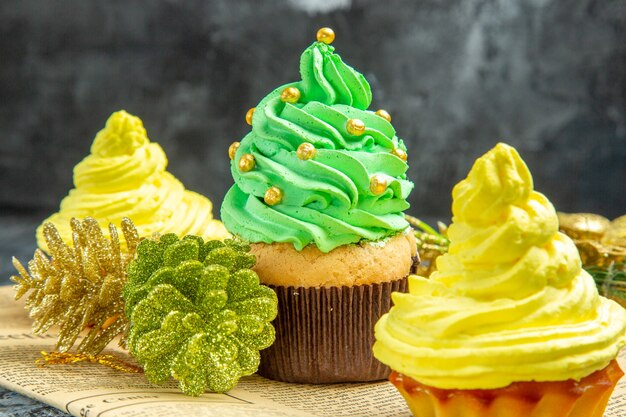 Vooraanzicht mini-cupcakes op krant op donkere kerstfoto