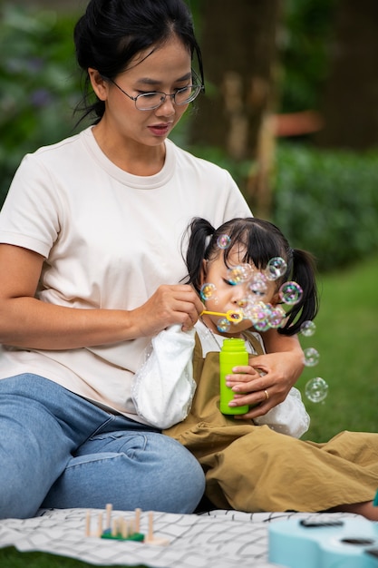 Gratis foto vooraanzicht moeder en meisje met picknick