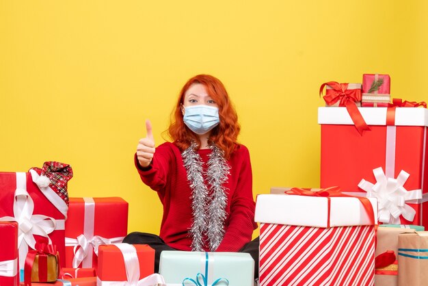 Vooraanzicht mooie vrouw rondhangen presenteert in masker op geel