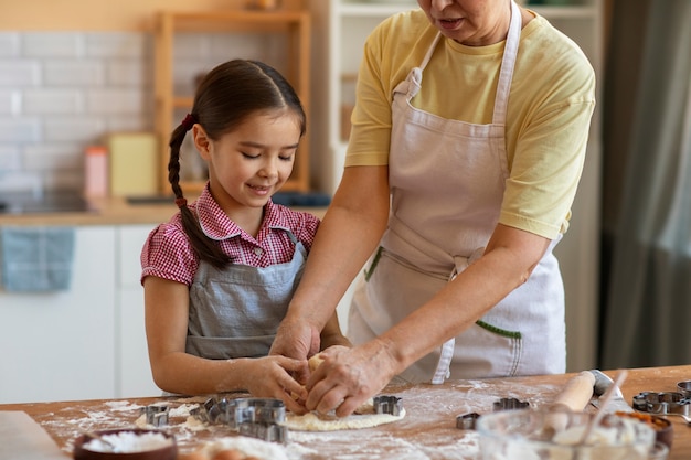 Gratis foto vooraanzicht oma en meisje samen koken