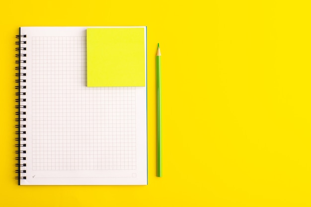 Vooraanzicht open voorbeeldenboek met gele sticker op geel bureau