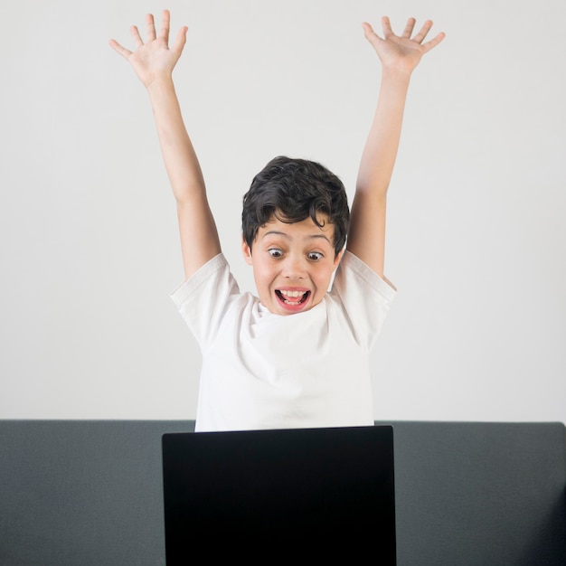 Vooraanzicht opgewonden jongen met laptop