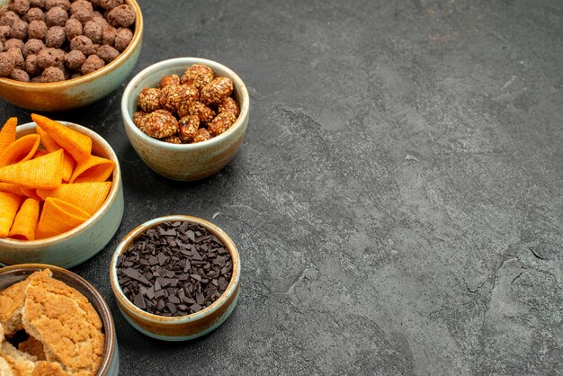 Vooraanzicht oranje cips met zoete noten en chocoladevlokken op grijze achtergrond maaltijd snack ontbijt noot