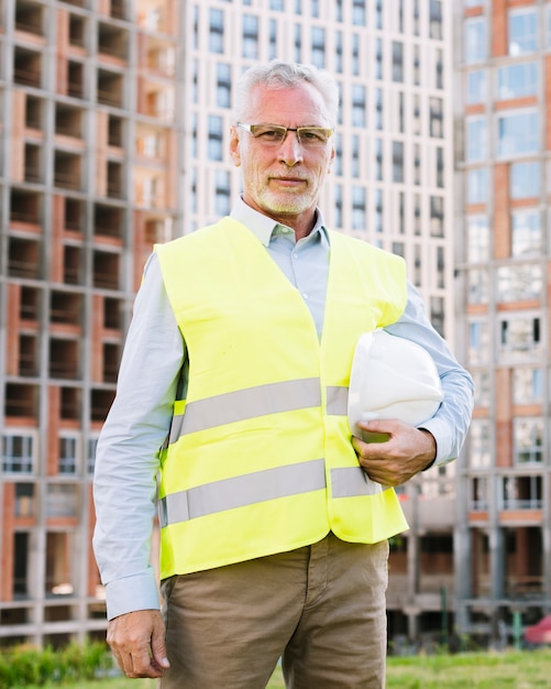 Vooraanzicht oude architect met vest en helm