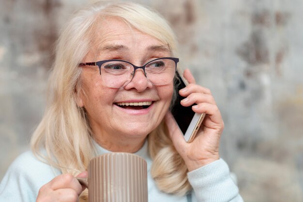 Vooraanzicht oudere vrouw praten via de telefoon