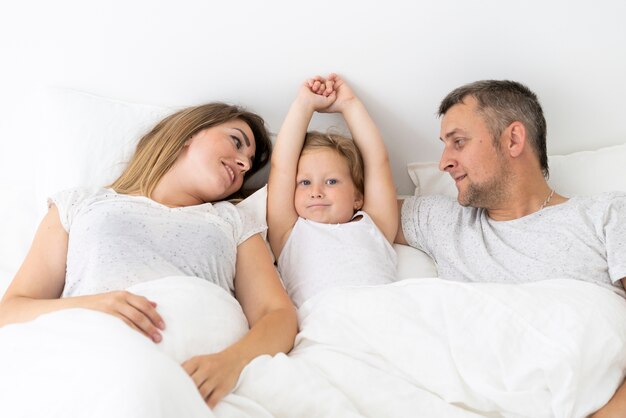 Vooraanzicht ouderzitting in bed met dochter