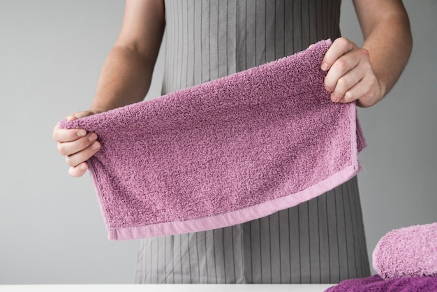 Gratis foto vooraanzicht persoon vouwen handdoeken