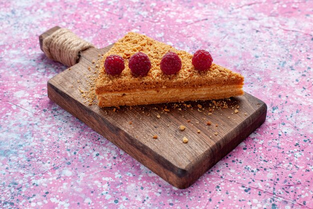 Vooraanzicht plakje cake gebakken en zoet met frambozen op het felroze bureau Bak zoete cake taart fruit