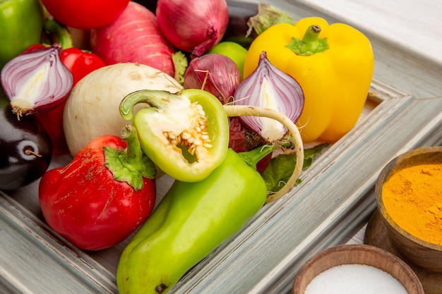 Vooraanzicht plantaardige samenstelling met kruiden op een witte achtergrond kleurenfoto groente gezond leven salade maaltijd rijp