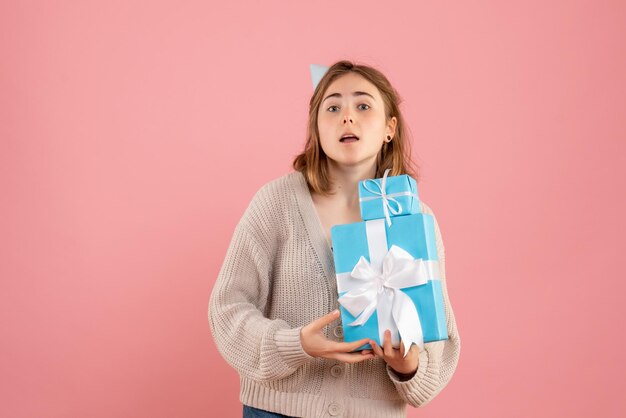 Vooraanzicht presenteert jonge vrouwelijke kerstcadeautjes