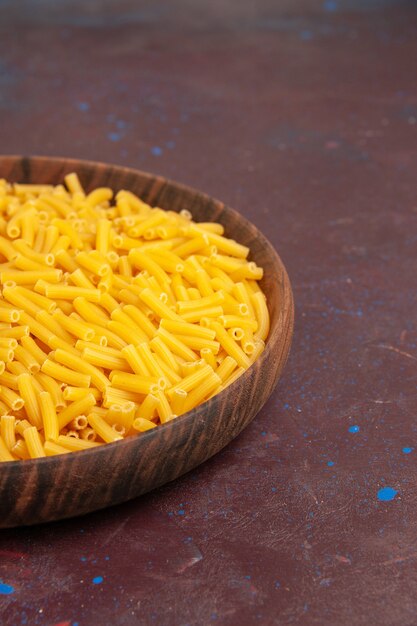 Vooraanzicht rauwe italiaanse pasta weinig gevormd binnen plaat op het donkere bureau