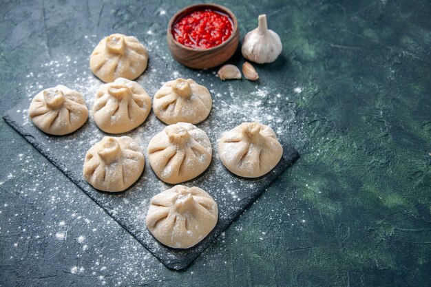 Vooraanzicht rauwe kleine knoedels met vlees binnen op donkere ondergrond vlees kleur schotel maaltijd keuken deeg bloem koken