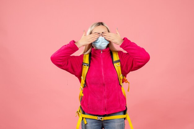 Vooraanzicht reiziger vrouw met gele rugzak dragen masker hand in hand over de ogen