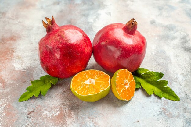 Vooraanzicht rode granaatappels citroenschijfjes op naakte achtergrond