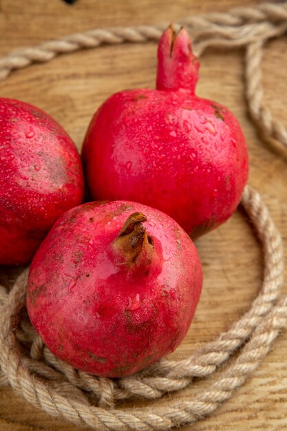 Vooraanzicht rode granaatappels met touwen op houten bureau kleur vruchtensap foto boom