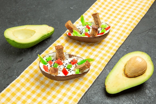 Gratis foto vooraanzicht romige avocado's met brood en peper op grijze ruimte