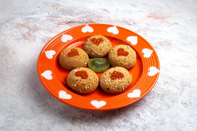 Gratis foto vooraanzicht ronde suikerkoekjes binnen plaat op witte het koekje van het oppervlaktekoekje de suiker zoete cake