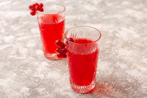 Vooraanzicht rood cranberrysap in glazen op helder bureau