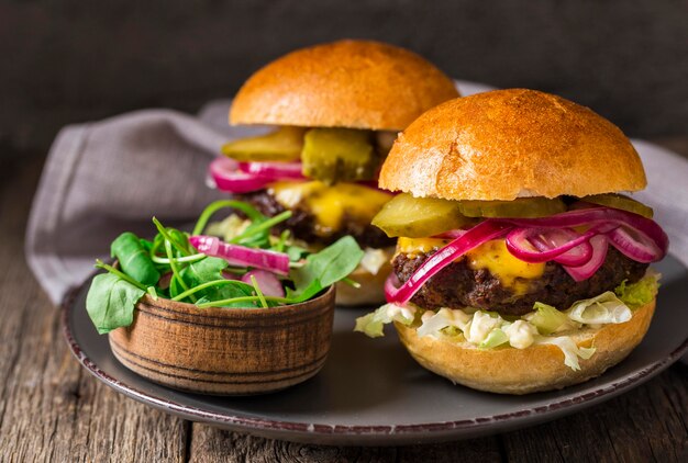 Vooraanzicht rundvleesburgers met augurken op snijplank