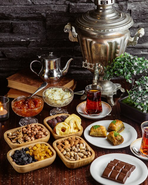 Vooraanzicht samovar theepot snoep theeservies chocoladereep pistachenoten gedroogde vruchten baklava met twee glazen armudu