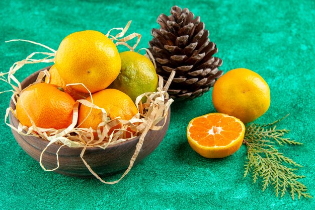 Vooraanzicht sappige verse mandarijnen binnen plaat op groene achtergrondkleur exotische zure citrusvruchten foto