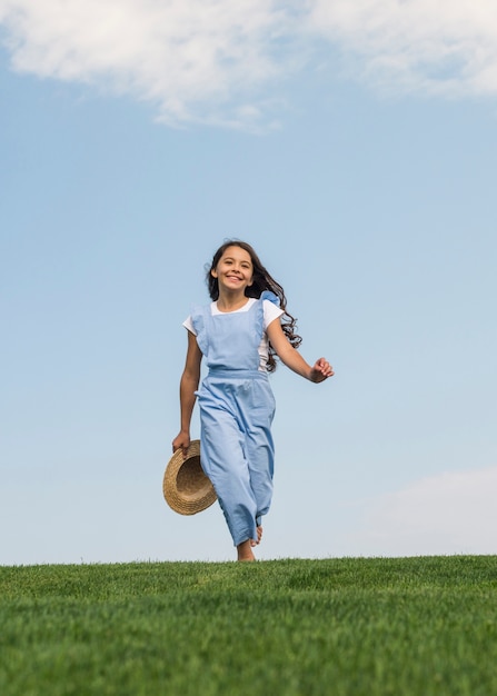 Vooraanzicht schattig meisje lopen op gras