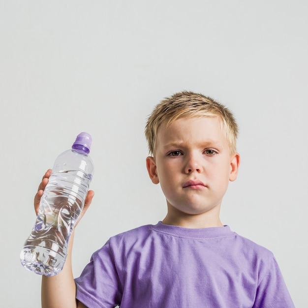 Vooraanzicht schattige jongen met een fles water