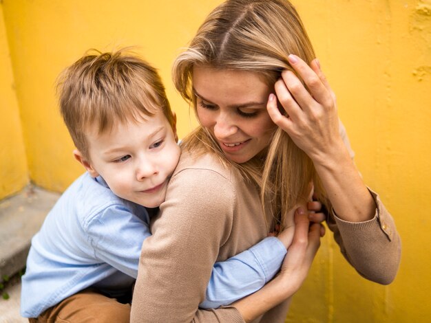 Vooraanzicht schattige zoon knuffelen zijn moeder