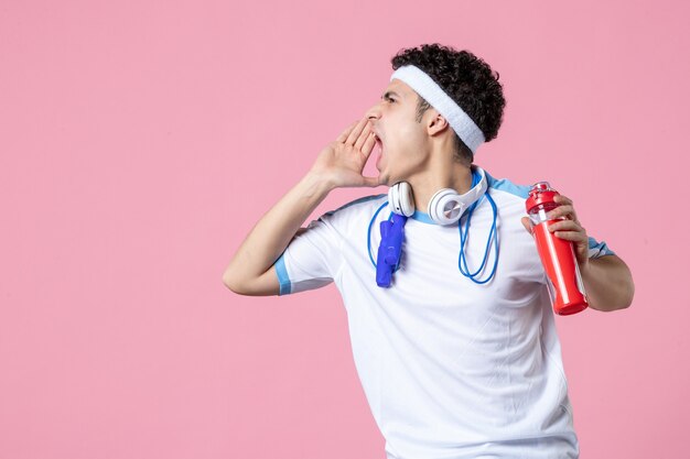 Vooraanzicht schreeuwende mannelijke atleet in sportkleding met springtouwen